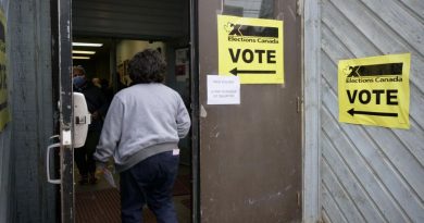 Une femme entre dans un bureau de vote.