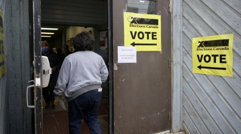 Une femme entre dans un bureau de vote.