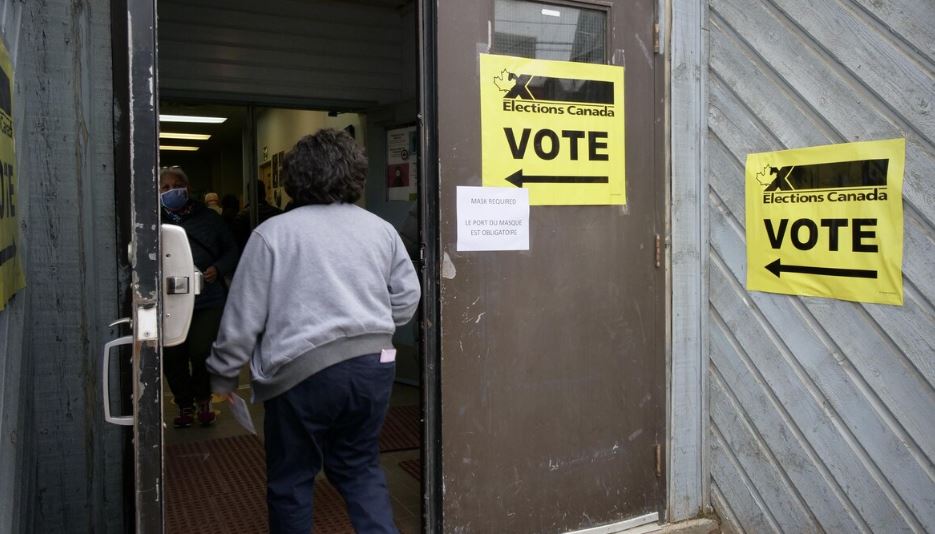 Une femme entre dans un bureau de vote.