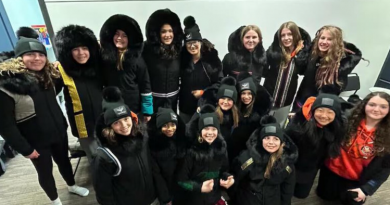 Un groupe de filles regarde vers la caméra. Elles portent tous un parka noir.