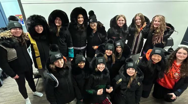Un groupe de filles regarde vers la caméra. Elles portent tous un parka noir.