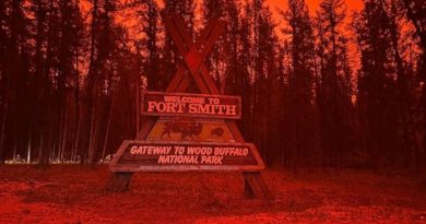 Le panneau d'entrée dans la ville de Fort Smith, dans un ciel rouge et enfumé par les feux.