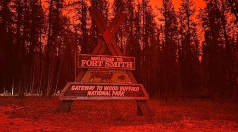 Le panneau d'entrée dans la ville de Fort Smith, dans un ciel rouge et enfumé par les feux.
