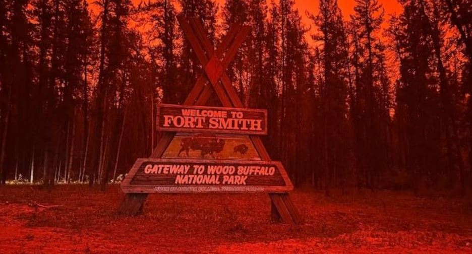Le panneau d'entrée dans la ville de Fort Smith, dans un ciel rouge et enfumé par les feux.