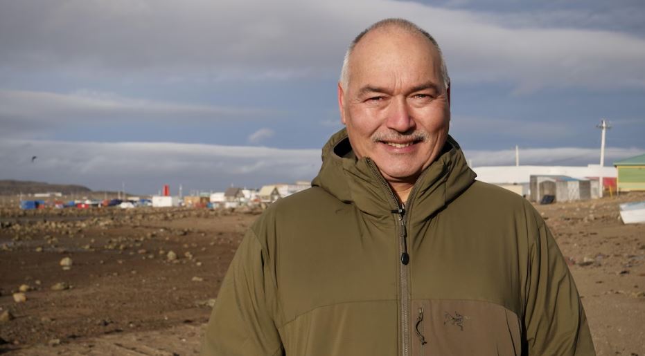 Joe Savikataaq devant une vue d'Iqaluit.