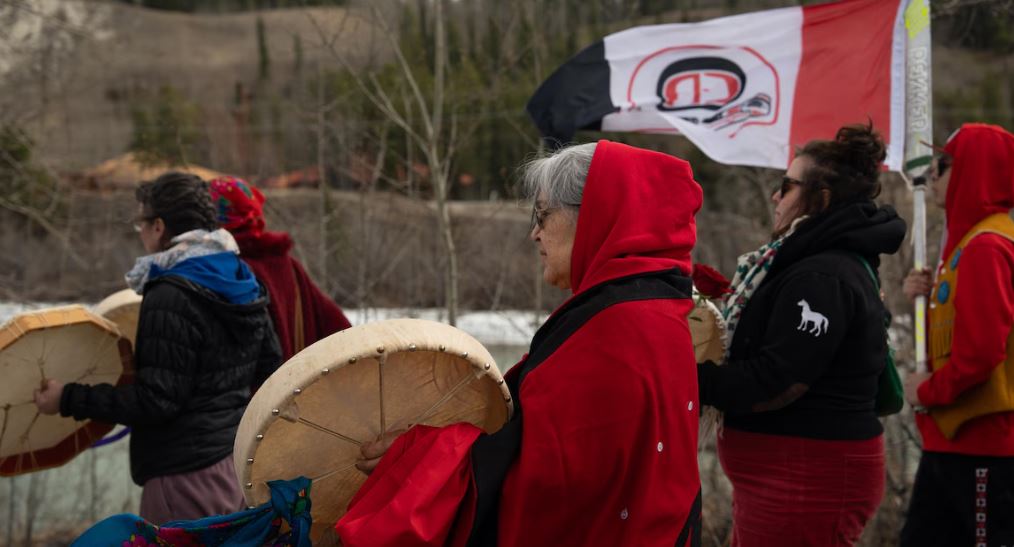 Une dame habillée de rouge tient un tambour, le 5 mai 2025.