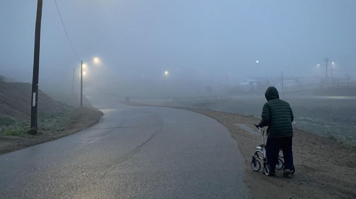 Un homme âgé marche dans une rue d'Iqaluit à l'aide d'une marchette.