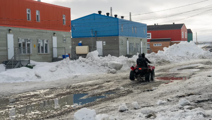 Une rue enneigée sur laquelle circule un VTT à quatre roues.