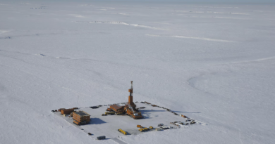 Une photo aérienne du site de forage du projet Willow, au milieu d'une étendue de neige déserte.