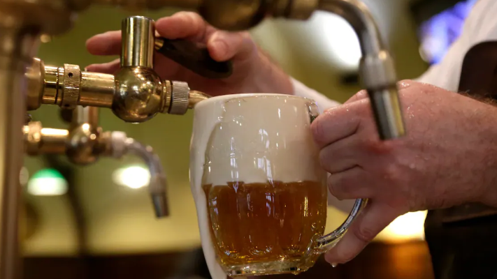 Une bière mousseuse est tirée dans un verre.
