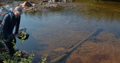 Un homme debout près d'un cours d'eau.