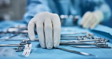 Les main d'un soignant manipulent des instruments chirurgicaux.