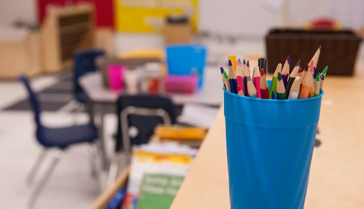 Une classe vide, des crayons en avant-plan.