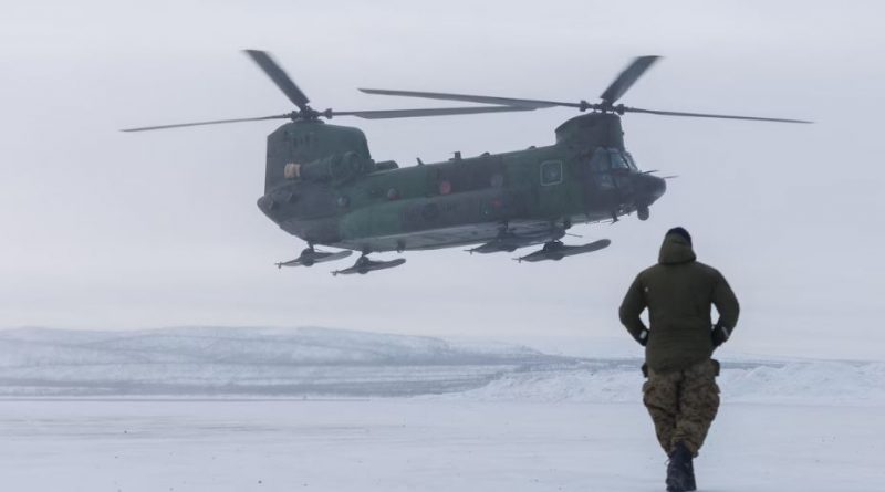 Un homme marche de dos vers un hélicoptère qui s'apprête à se poser au sol durant l'opération militaire Nanook, dans le nord des Territoires du Nord-Ouest, le 1er mars 2025.
