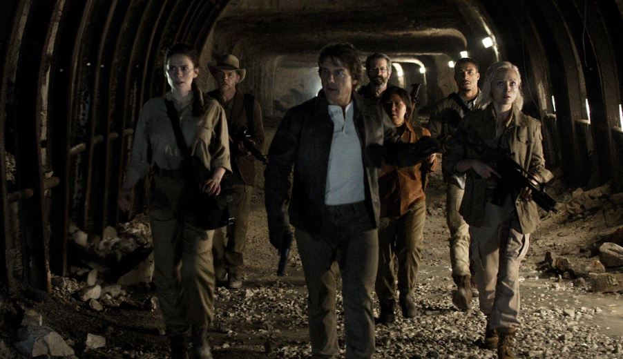 Une scène de film montrant les acteurs Lucy Tulugarjuk, Tom Cruise, Hayley Atwell, Simon Pegg et Rolf Saxon dans un tunnel.