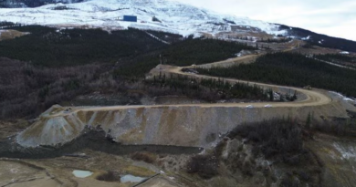 Plan d'ensemble d'un talus de terre sur lequel circulent des camionnettes à l'automne.