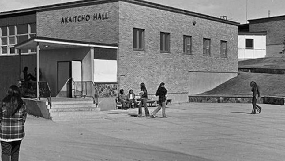 Une image en noir et blanc d'élèves sur le terrain d'Akaitcho Hall, à Yellowknife.