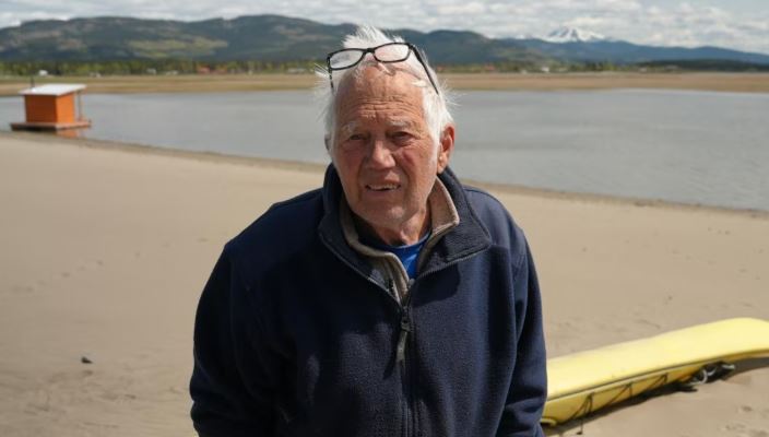 Un homme se tient sur une plage, sur les berges du lac Marsh, au Yukon.
