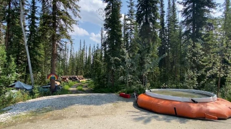 Un réservoir d’eau devant l'entrée vers une propriété dans les bois, le 25 juin 2025.
