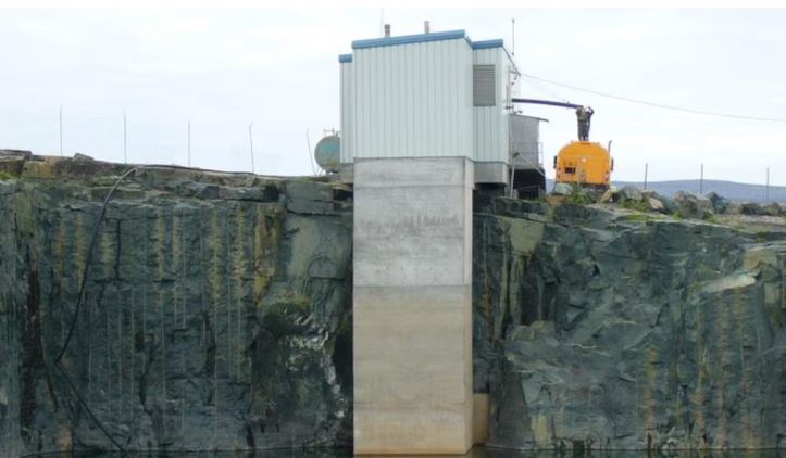 Une station de traitement des eaux au bord d'un mur de roche.