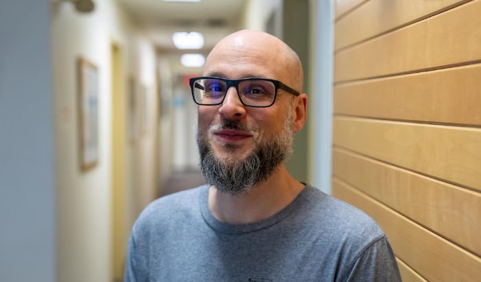 Portrait de Robert Delatolla, avec des lunettes et une barbe. 