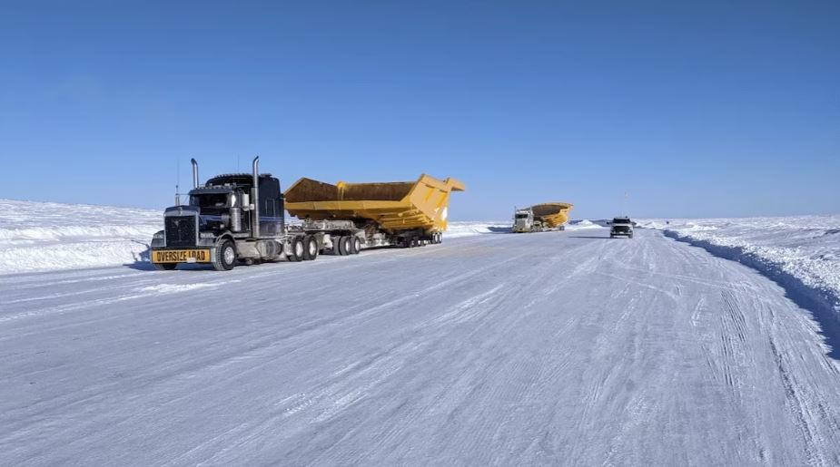 Des camions sur une route glacée et enneigée.