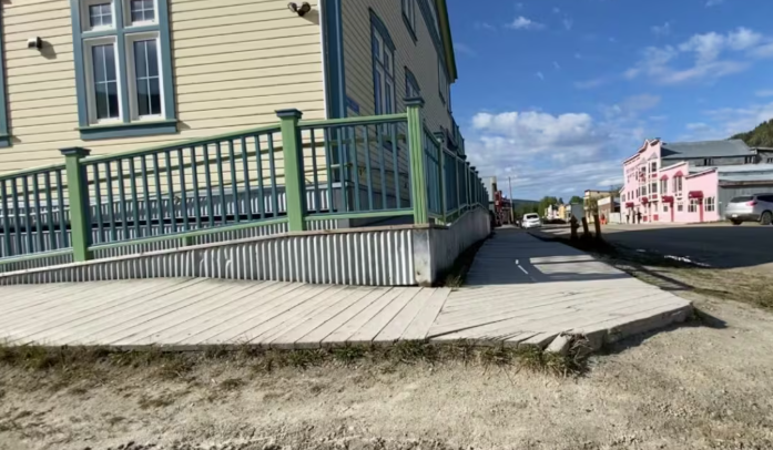 Un trottoir de bois longeant un bâtiment.