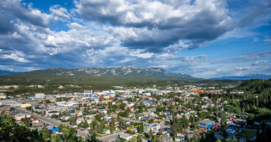 Une vue en hauteur de la ville de Whitehorse mélangeant arbres et bâtiments.