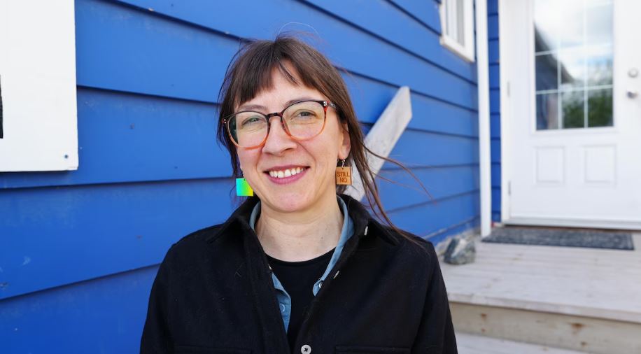 Audrey Fournier devant la maison bleue, le siège de la Fédération franco-ténoise.