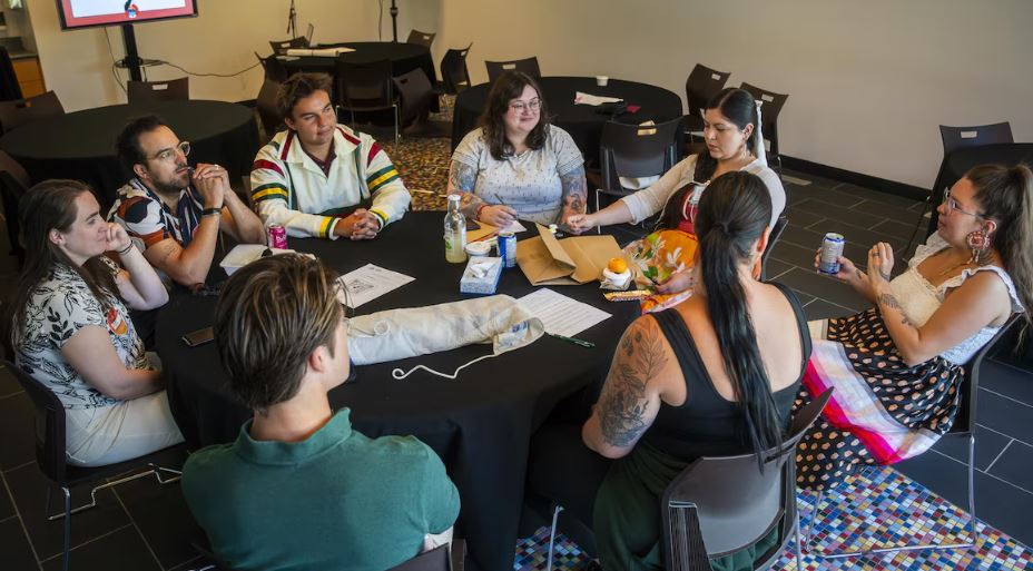Une réunion de huit personnes autour d'une table.