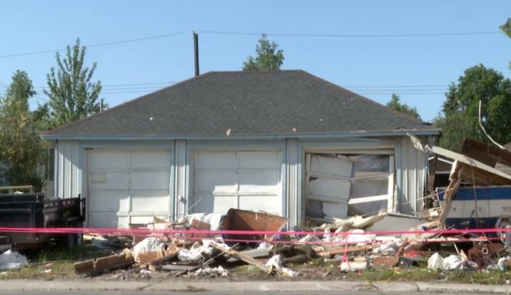 Des débris des suites de l'explosion entourent un bâtiment.
