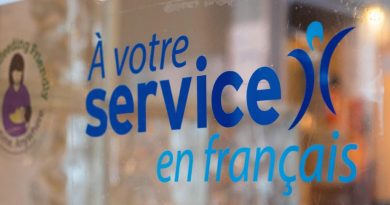 Une étiquette dans une fenêtre où l'on peut lire « À votre service en français ».