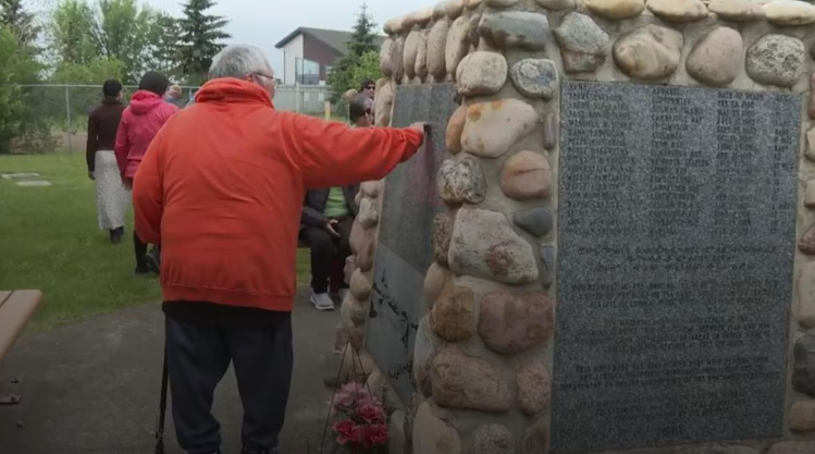 Un homme marche près d'un monument sur le site de l'ancien hôpital Charles Camsell. 