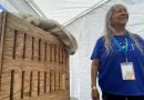 Joanne Williams se tient debout près d'une boîte en bois cintré.