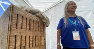Joanne Williams se tient debout près d'une boîte en bois cintré.