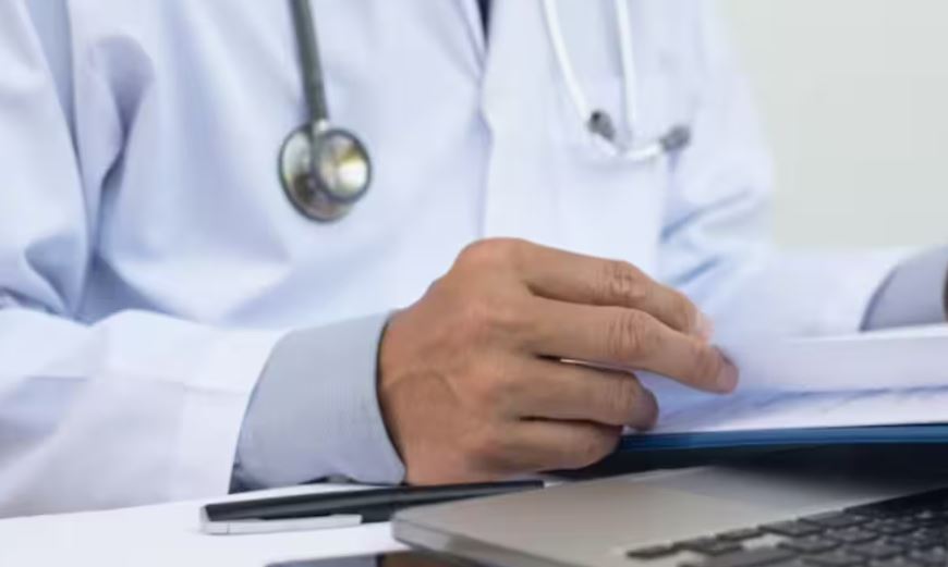 Un médecin prend des feuilles entre ses doigts.