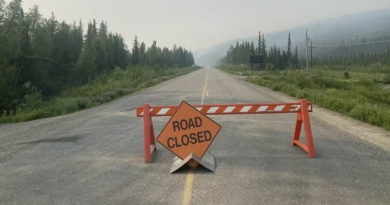 Un panneau Road Closed sur une route au Yukon avec beaucoup de fumée, en juin 2025.