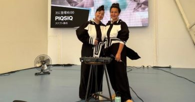 Les deux sœurs du duo PIQSIQ posent souriantes sur scène, vêtues de tenues noires et blanches d’inspiration traditionnelle.