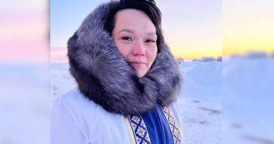Portrait de Virginia qui porte un manteau d'hiver traditionnel blanc.