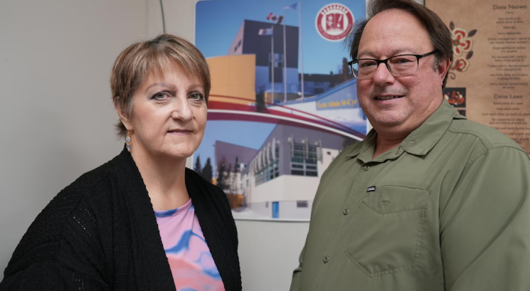Portraits de Yvonne Careen et François Rouleau, tous deux de profil devant une affiche de l'école Alain St-Cyr.