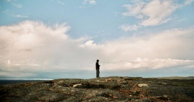 Un homme regarde vers l'horizon, dans la toundra.