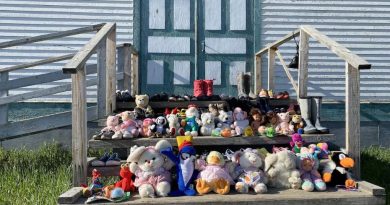 Des peluches, jouets et petites chaussures remplissent les trois marches devant l'entrée de l'Église catholique à Fort Resolution, aux T.N.-O.
