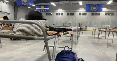 Des lits de camps dans un gymnase.