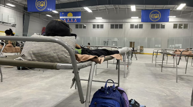 Des lits de camps dans un gymnase.