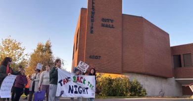 Des personnes avec une bannière Take Back the Night devant l'hôtel de ville de Yellowknife, le 18 septembre 2025.