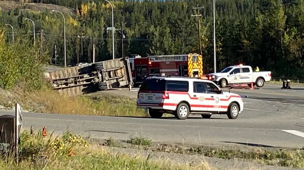Des véhicules d'urgence sont à proximité d'un camion renversé sur l'autoroute.