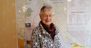Ione Christensen devant une carte du Yukon.