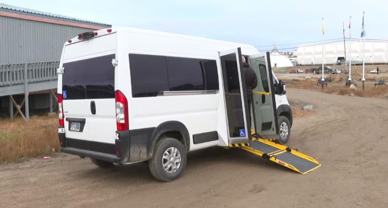 Une image d’une fourgonnette blanche équipée d’une rampe pour fauteuil roulant.