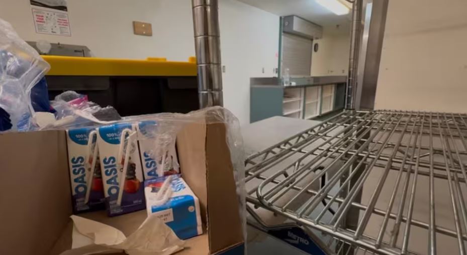 Des boîtes de jus dans un carton posé sur une étagère.