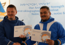 Deux hommes se serrent la main tout en montrant un document.